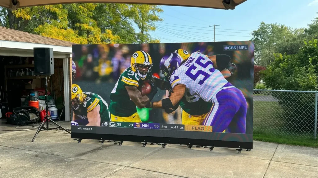 Outdoor LED video wall showing a football game for a watch party